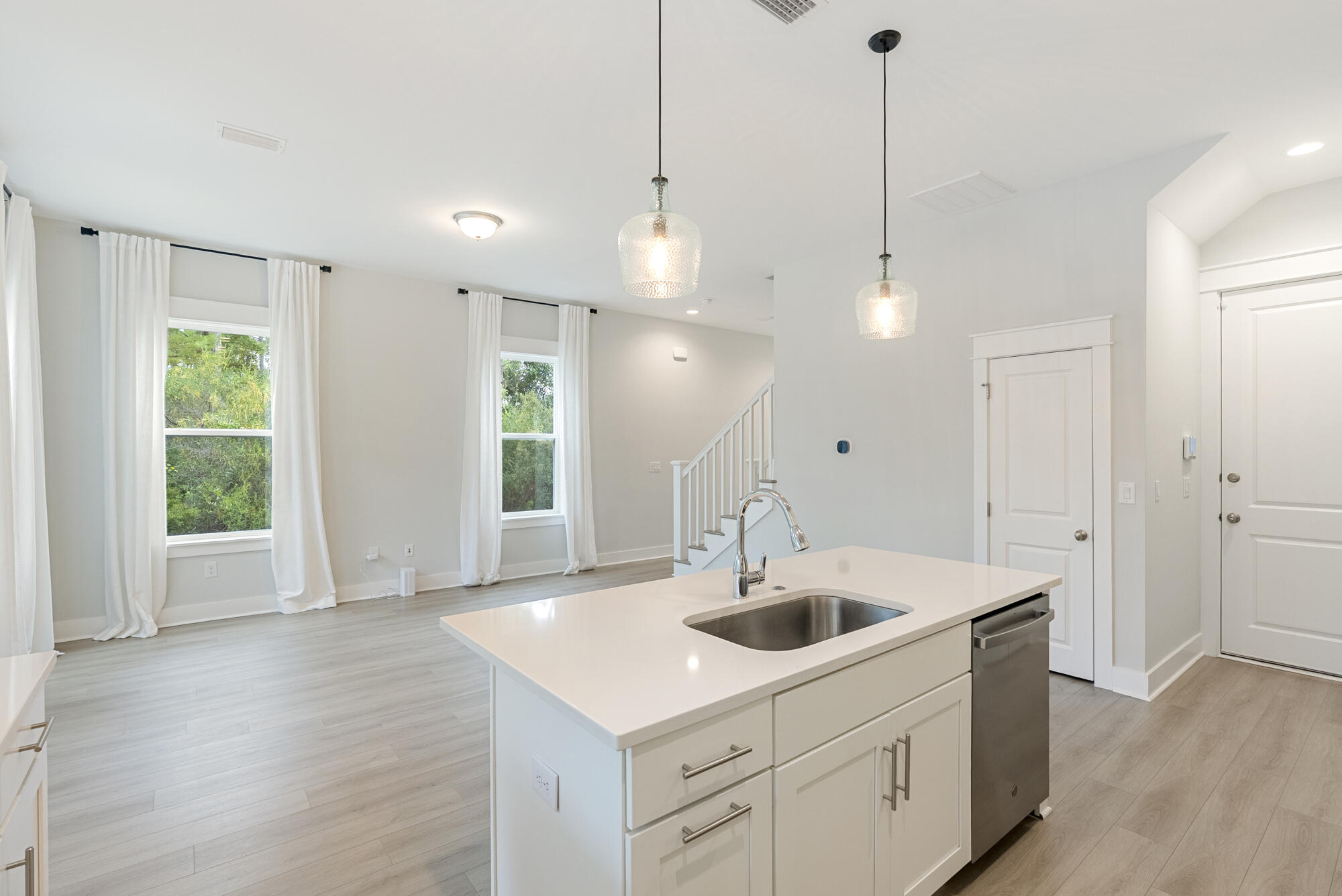 248 Euvino Way Santa Rosa Beach, FL 32459 - Photo 18 of 56 a kitchen with stainless steel appliances a sink a wooden floor and a large window
