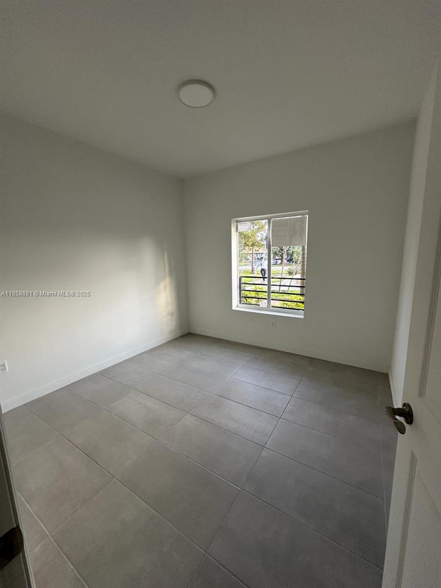 541 Southwest 2nd Court, Unit 5 Pompano Beach, FL 33060 - Photo 20 of 20 an empty room with a window and a fireplace