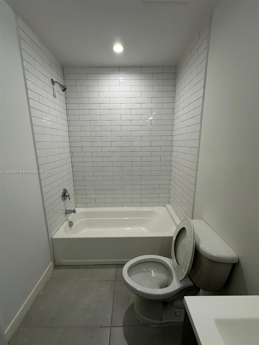 541 Southwest 2nd Court, Unit 5 Pompano Beach, FL 33060 - Photo 10 of 20 a bathroom with a bathtub shower sink vanity and toilet