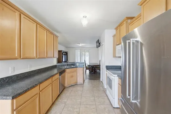 a kitchen with stainless steel appliances granite countertop a refrigerator and a stove top oven