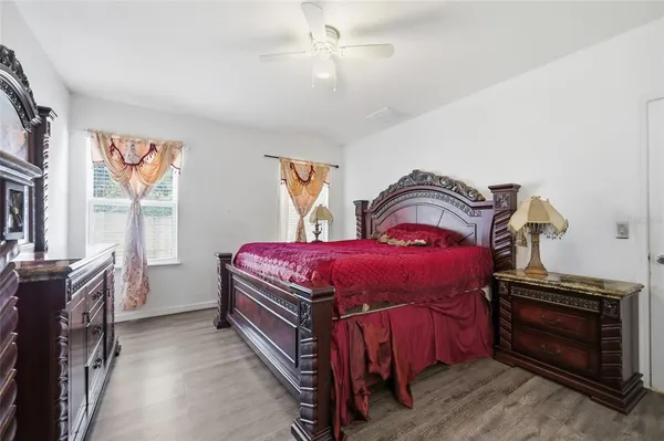 a bedroom with a bed and a flat tv screen on dresser