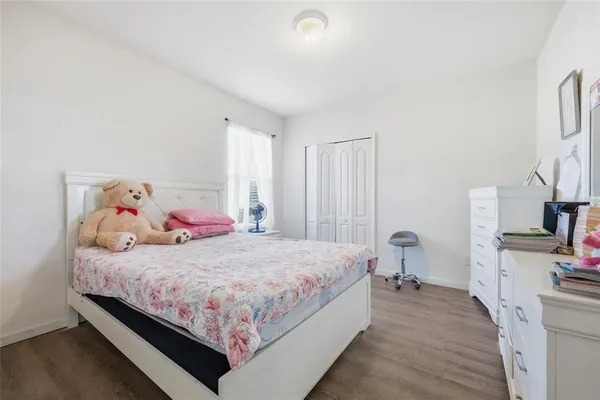 a bedroom with a bed and a flat tv screen on the dresser