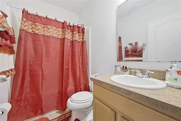 a bathroom with a sink a toilet and shower curtain