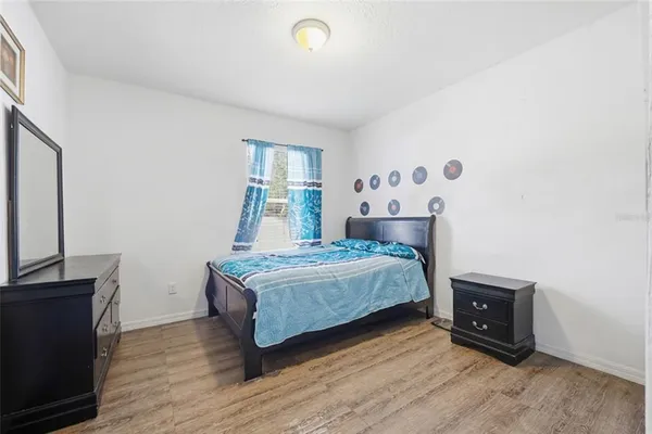 a bedroom with a bed and wooden floor