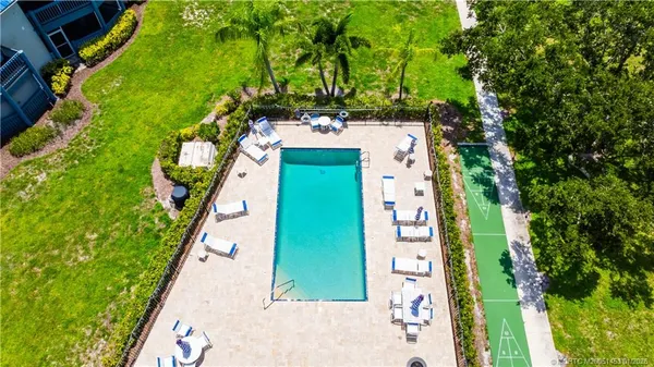 a view of a swimming pool with a lawn chairs and a dining space