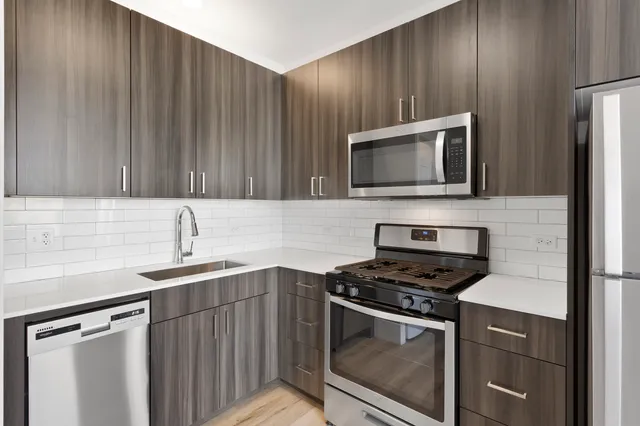 a kitchen with cabinets stainless steel appliances and sink