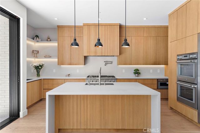 a kitchen with stainless steel appliances a sink stove and cabinets