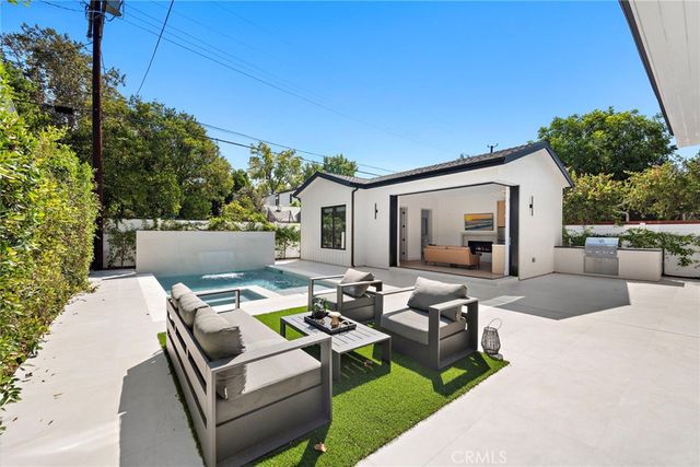 a view of a patio with couches table and chairs and potted plants