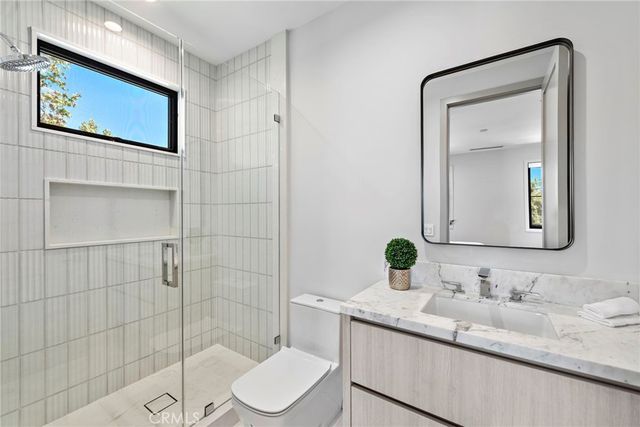 a bathroom with a granite countertop sink mirror and toilet