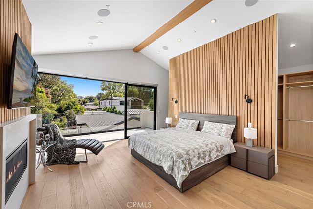 a bedroom with a bed and a flat tv screen on dresser
