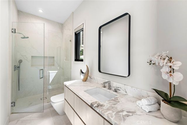 a bathroom with a granite countertop sink a toilet and shower