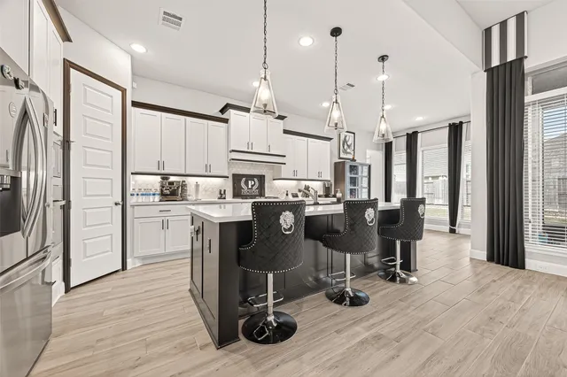 a view of kitchen with stainless steel appliances refrigerator dining table and chairs
