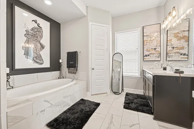 a bathroom with a tub sink and mirror