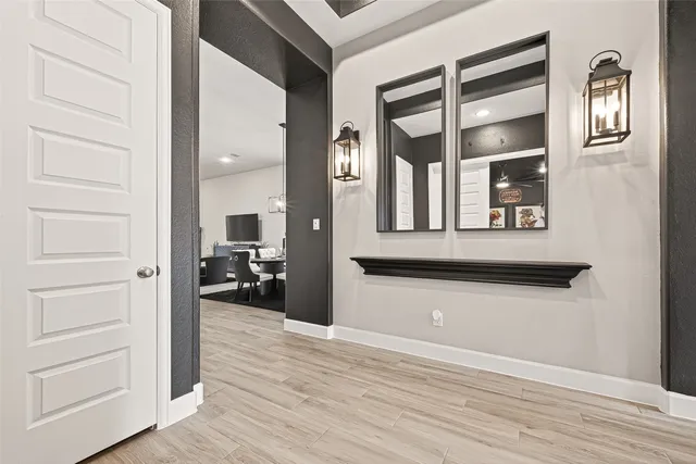 a view of a hallway with wooden floor and a cabinet