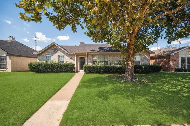 a front view of a house with a garden and yard