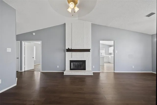 a view of a livingroom with wooden floor and a fireplace