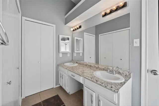 a bathroom with a granite countertop sink and a mirror