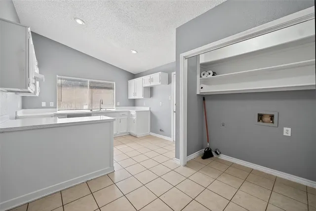 a kitchen with white cabinets and sink
