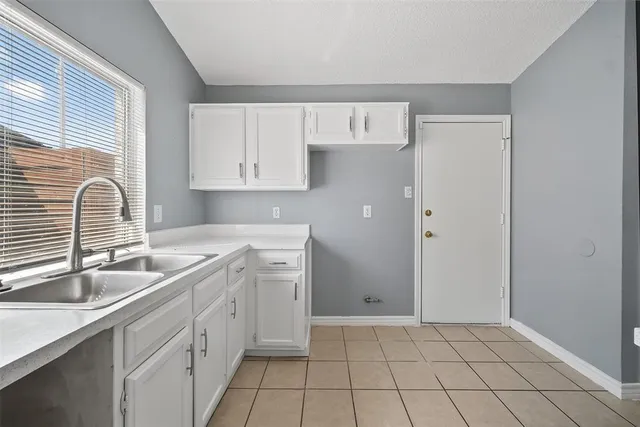 a kitchen with a sink cabinets and window