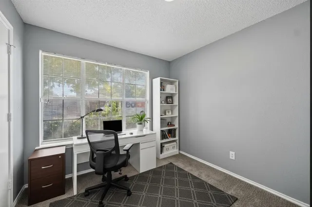 a view of a workspace with furniture and a window