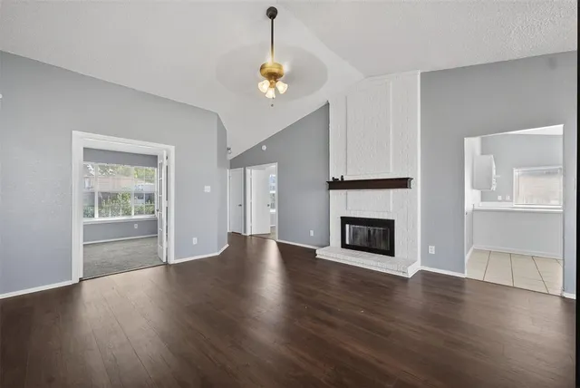 a view of a livingroom with wooden floor fireplace and window