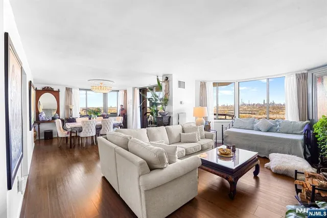 a living room with furniture wooden floor and a large window