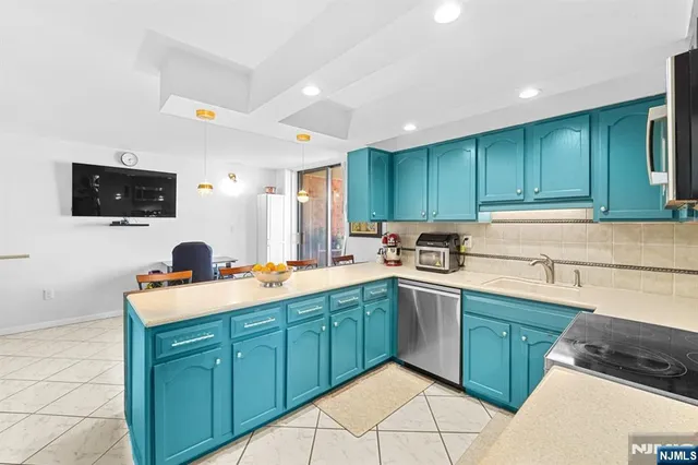 a kitchen with stainless steel appliances granite countertop a sink and a stove top oven with wooden floor