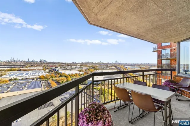 a view of a balcony with wooden chairs and ocean view