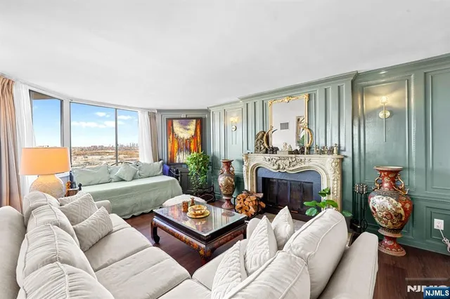 a living room with furniture fireplace and a large window