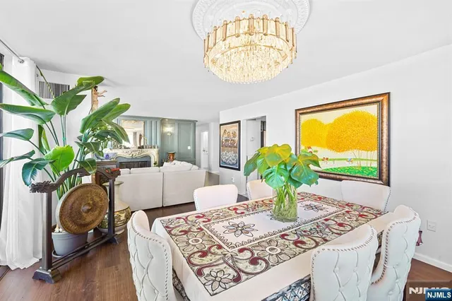 a living room with furniture a chandelier and a dining table