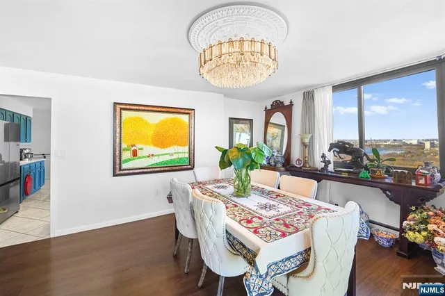a view of a dining room with furniture a chandelier and wooden floor