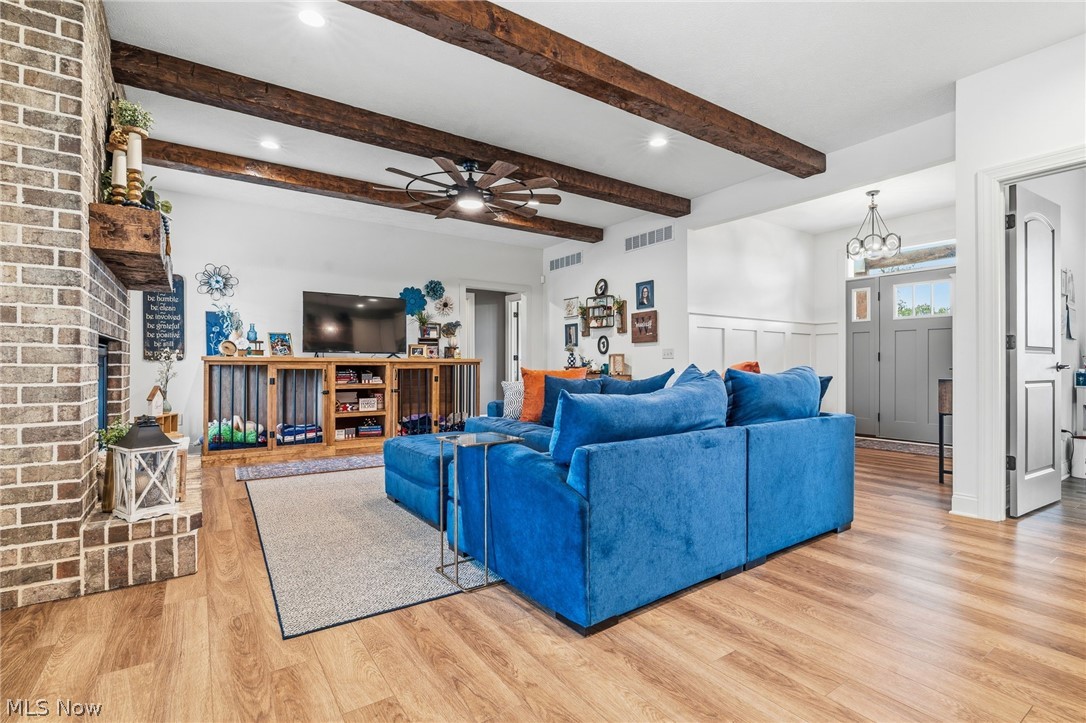 421 Pontius Road Mogadore, OH 44260 - Photo 8 of 50 Exposed wood ceiling beams, brick fireplace with wood mantel, wood-finish flooring, recessed lighting, and a ceiling fan