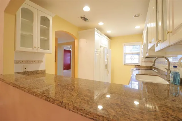 a view of a bathroom with a granite countertop sink a toilet and bathtub