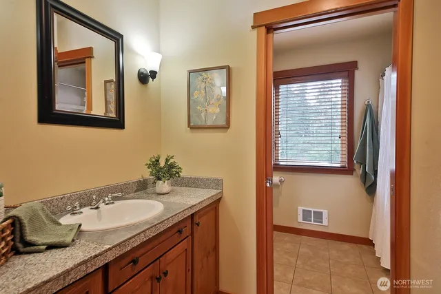 a bathroom with a granite countertop sink and a mirror
