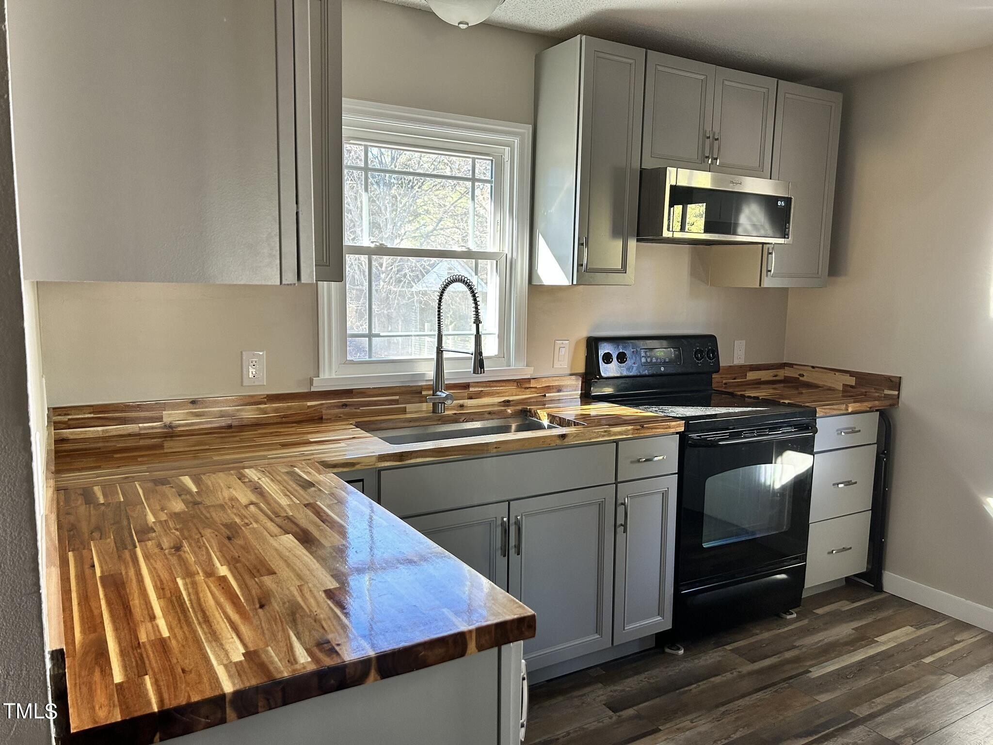 13535 Cleveland Road Garner, NC 27529 - Photo 7 of 18 a kitchen with stainless steel appliances granite countertop a sink stove and microwave