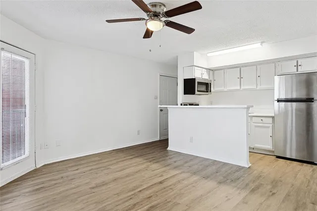a view of kitchen with wooden floor and electronic appliances