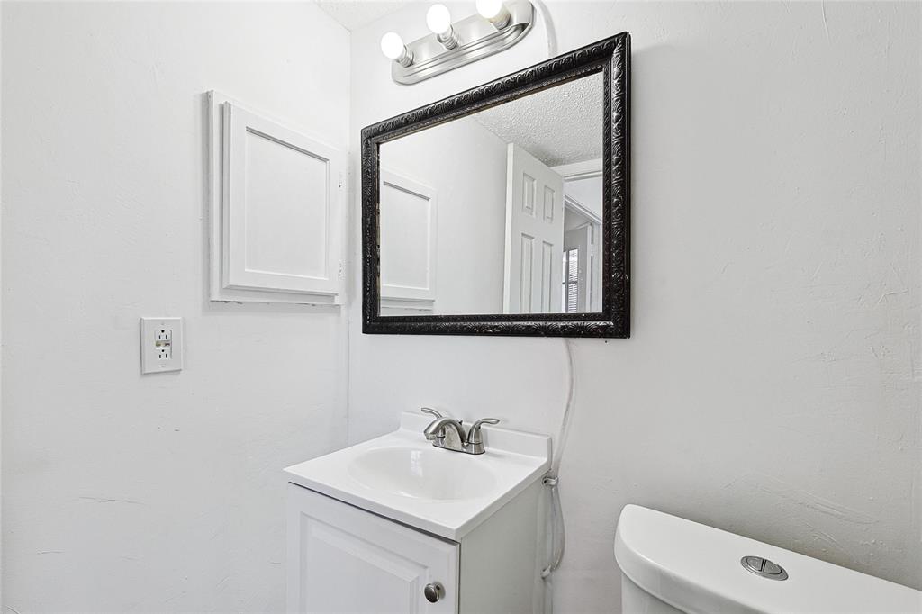 9839 Walnut Street, Unit 306 Dallas, TX 75243 - Photo 24 of 33 a bathroom with a toilet sink vanity and mirror