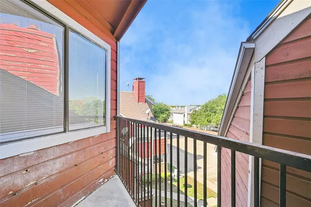 a view of a balcony with wooden floor and fence