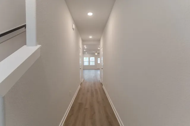 a view of a hallway with wooden floor