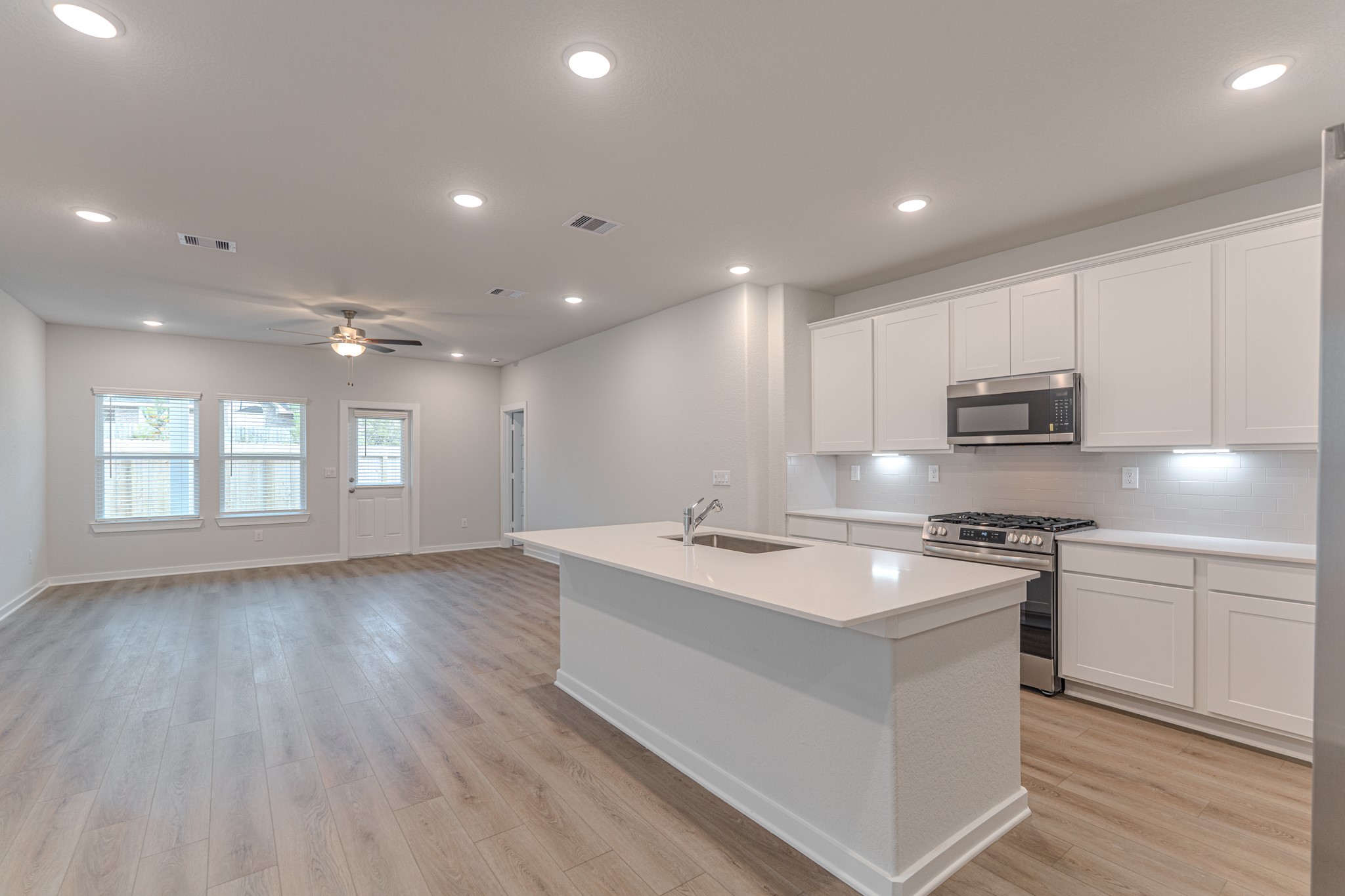 8570 Blueberry Ash Street Magnolia, TX 77354 - Photo 5 of 30 a kitchen with stainless steel appliances granite countertop a sink dishwasher a stove and a refrigerator with wooden floor