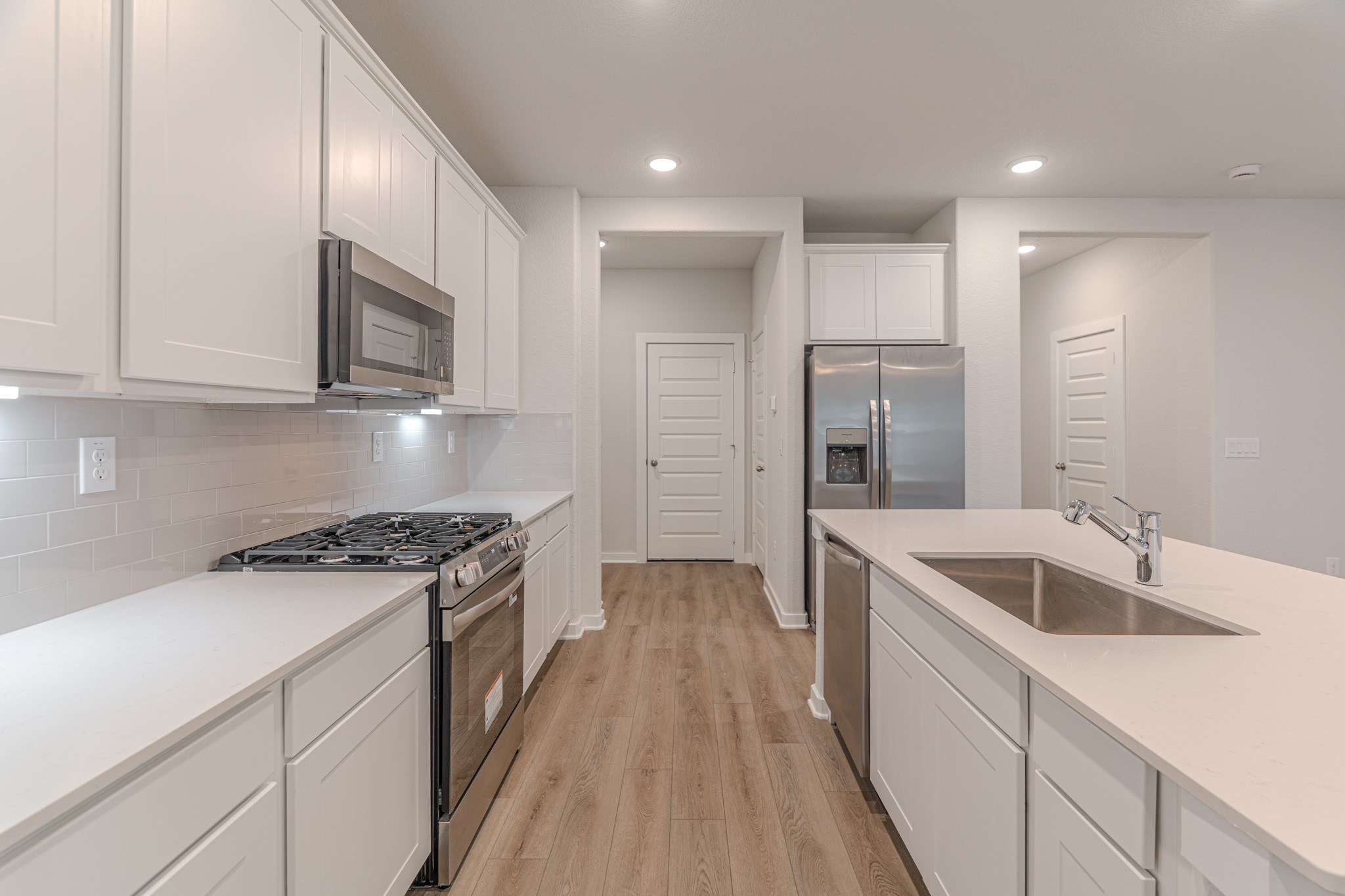 8570 Blueberry Ash Street Magnolia, TX 77354 - Photo 7 of 30 a kitchen with stainless steel appliances granite countertop a sink stove and refrigerator