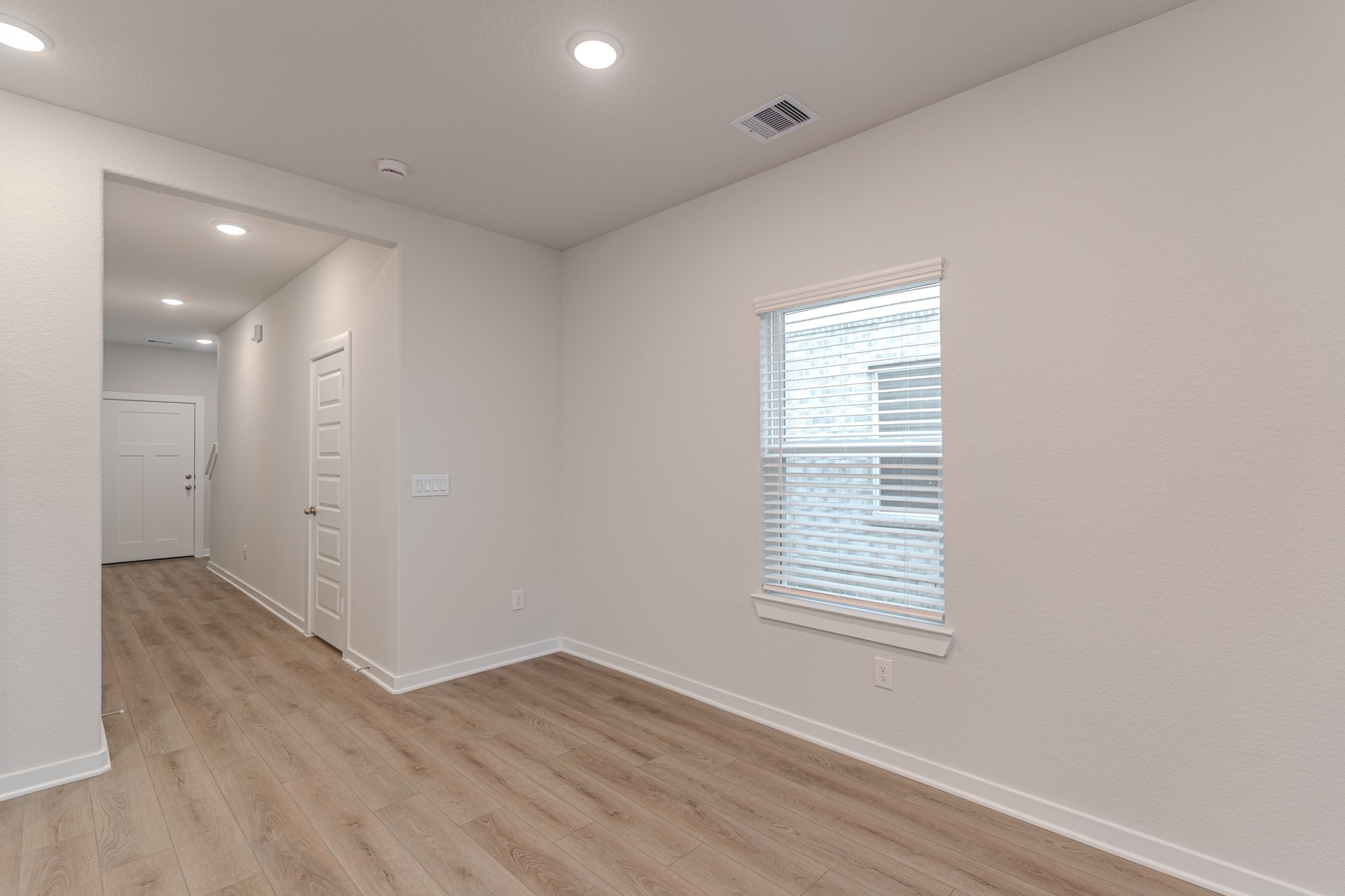 8570 Blueberry Ash Street Magnolia, TX 77354 - Photo 9 of 30 a view of an empty room with wooden floor and a window