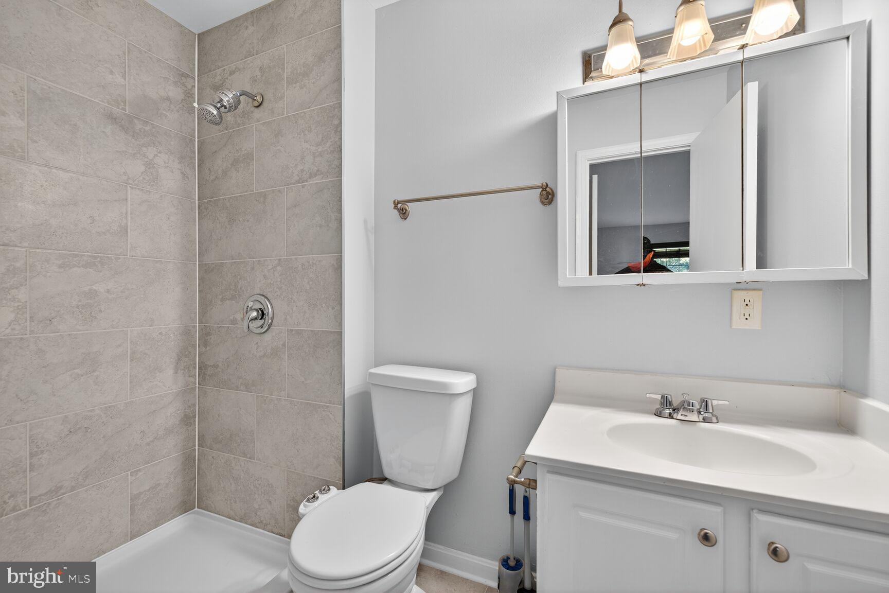 18318 Streamside Drive, Unit 302 Gaithersburg, MD 20879 - Photo 11 of 17 a bathroom with a sink a toilet and shower