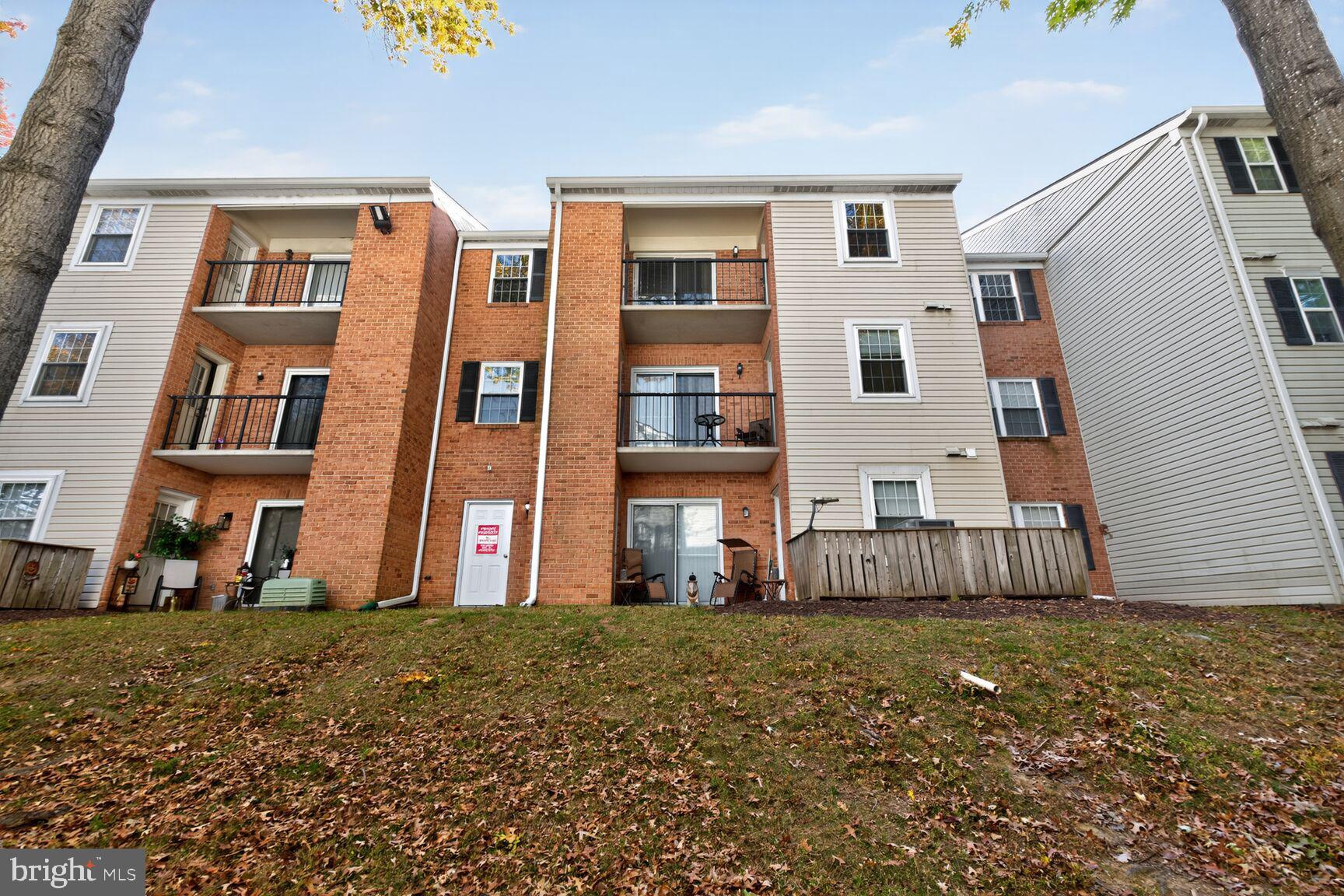18318 Streamside Drive, Unit 302 Gaithersburg, MD 20879 - Photo 15 of 17 a front view of a house with a garden