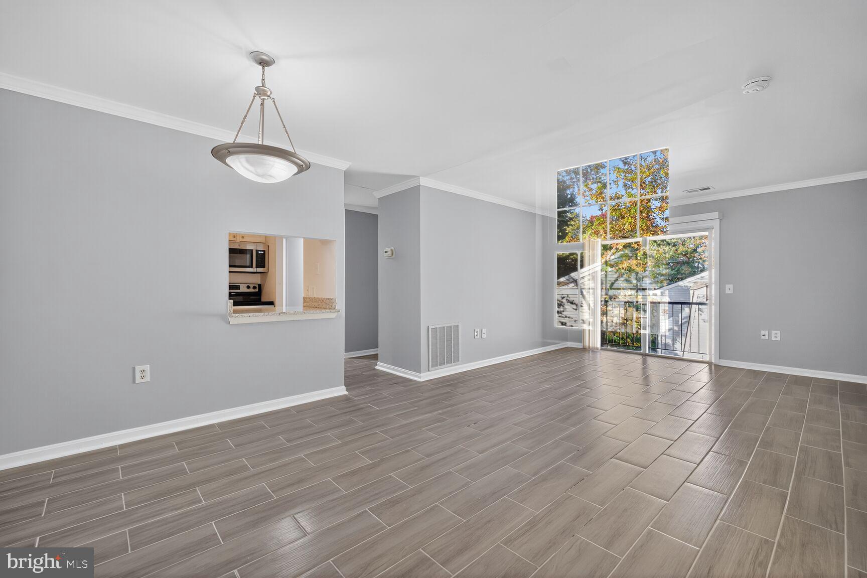 18318 Streamside Drive, Unit 302 Gaithersburg, MD 20879 - Photo 3 of 17 wooden floor in an empty room with a window