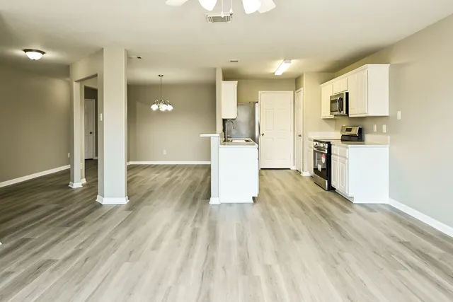 a view of a kitchen with wooden floor and electronic appliances