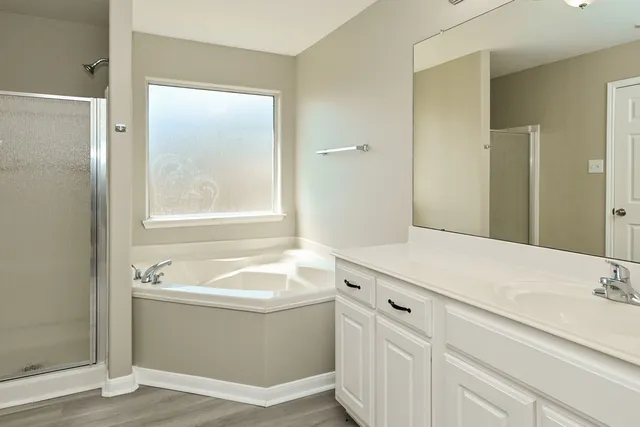 a bathroom with a tub sink and mirror