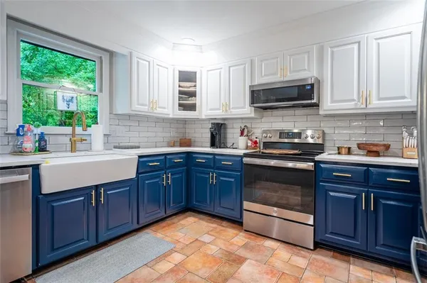 a kitchen with stainless steel appliances granite countertop a stove a sink dishwasher and a microwave oven with cabinets