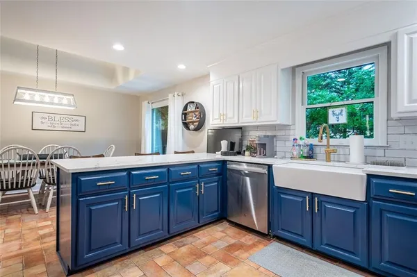 a kitchen with stainless steel appliances granite countertop wooden cabinets a sink and dishwasher with wooden floor