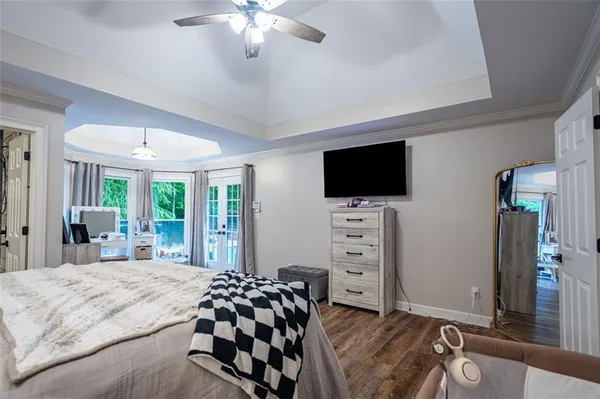 a bedroom with a bed and a flat tv screen on dresser